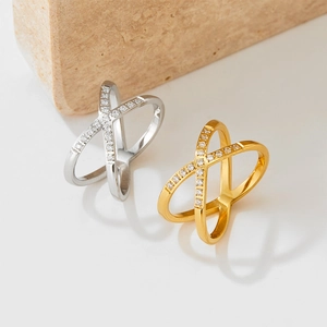 Crossed X-shape stainless steel rings in gold and silver with shimmering pavé zircon stones