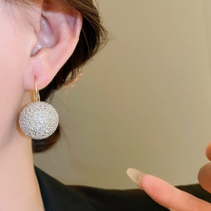 Close-up of sparkling crystal ball hoop earrings on a model for a luxury jewelry look