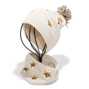 Close-up of knit winter hat and scarf set featuring cute orange fox patterns