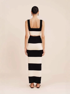 Women's two-piece knitted set featuring black and white striped crop top and maxi skirt