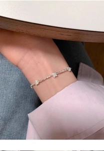 Primo piano di un bracciale a farfalla in argento sterling S925 indossato sul polso elegante