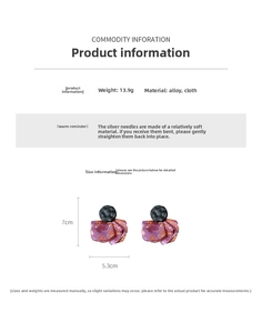Detail of purple fabric petal earrings with silver pins and round black accents