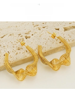 Detail showing the spiral texture and C-shape design of the golden spring earrings