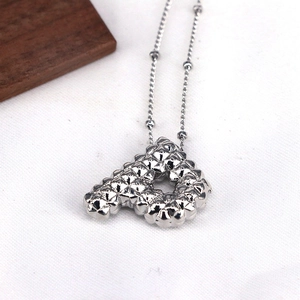 Macro view of silver letter A pendant with diamond texture and fine bead chain