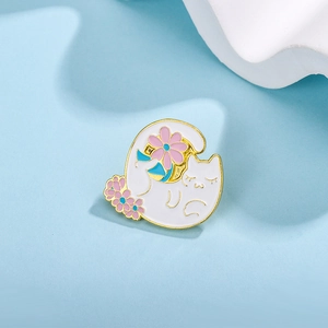 Detailed view of a white yoga cat enamel pin featuring pink flowers and golden edges