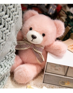 Close-up of pink long-haired teddy bear with purple bow tie and fluffy texture