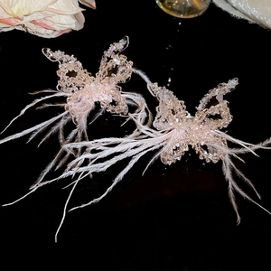 Detail of pink crystal butterfly pendant with soft white feathers on long sweater chain