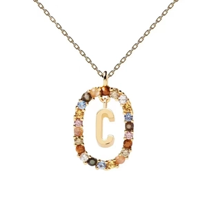 Close-up of gold-plated necklace pendant with colorful zircons in the shape of letter C