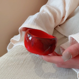 Detail view of a translucent deep red resin cuff with marbled ink texture effect