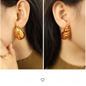 Detail view of gold 18K plated drop earrings and spiral stud with mirror finish