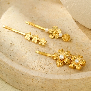 Three gold flower hair clips with pearls on a stone plate, luxury hair accessories set