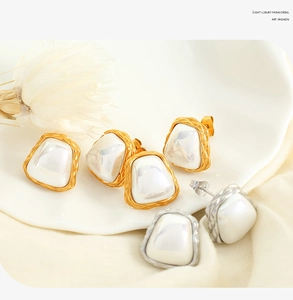 Detail of irregular geometric pearl earrings with textured gold and silver metal edges