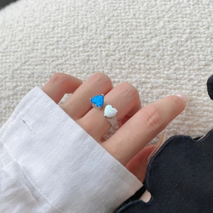 Dettaglio dell'anello in argento S925 con opali a forma di cuore blu e bianco