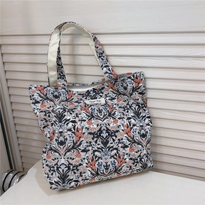 Close-up of vintage floral cotton handbag featuring detailed flower patterns and simple wish label