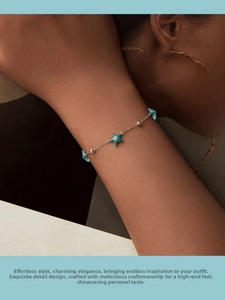 Macro detail of S925 sterling silver starfish bracelet with green enamel on female wrist