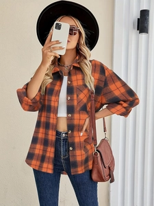 Close-up of orange and black plaid shirt with classic collar and front pocket