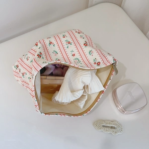 Gros plan d'une trousse à maquillage en coton à fleurs et fraises avec fermeture éclair