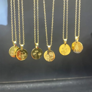 Detail of six golden oval pendants featuring intricate floral engravings on titanium steel