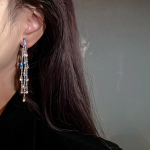 Close-up of elegant silver long tassel earrings with sparkling zircon crystals on model