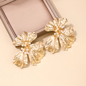 Chic golden oversized flower earrings with central white pearls in a jewelry box
