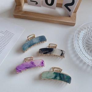Set of four 7.5cm acetate hair claws with marble texture and golden metal grip