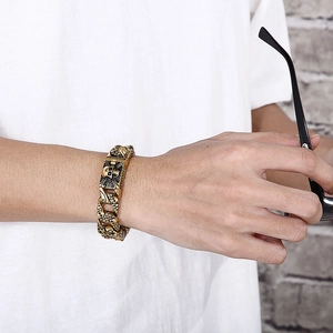 Detailed view of men's gold punk skull bracelet with intricate textured engraving
