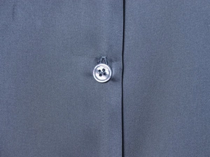 Detailed close-up of dark grey satin fabric texture and premium buttons on the shirt