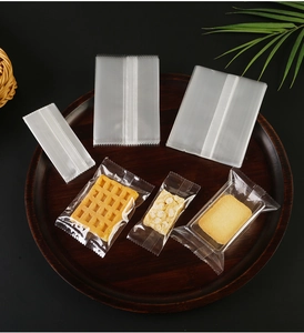 Close-up of transparent food-grade heat seal bags for cookies and snacks on wood tray
