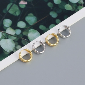 Detailed view of gold and silver 925 sterling silver quilted hoop earrings with small diamonds