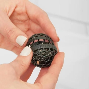 Macro shot of a black sticky cleaner ball for handbags with honeycomb plastic shell