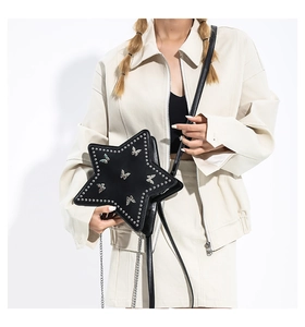 Detail showing a black star-shaped crossbody bag with silver butterfly and rivet accents