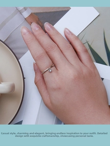 Detail of a minimalist 925 silver ring with a cute hanging cat paw charm on finger