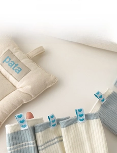 Close-up of cream and blue striped crew socks with blue heart fabric label detail