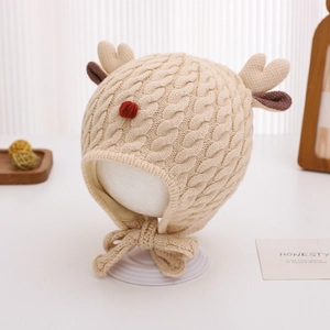 Close-up of beige knit baby hat with reindeer antlers and festive red pom-pom nose