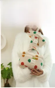 Macro detail of plush beige toiletry bag with colorful polka dots and floral zipper pull