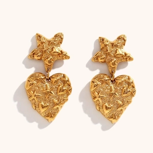 Detail of vintage gold star and heart drop earrings with embossed texture details