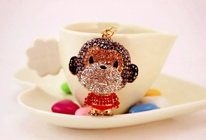 Macro shot of rhinestone-encrusted monkey keychain with vibrant red and brown crystals