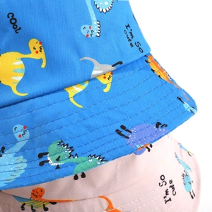 Close-up of pink and blue kids dinosaur sun hats with detailed stitching and soft fabric