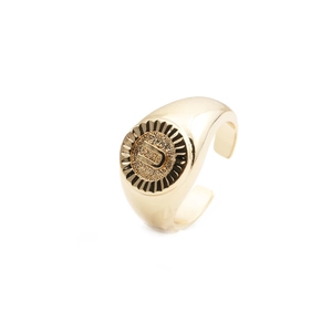 Detail shot of a gold-plated signet ring featuring an engraved letter U with sunburst ridges