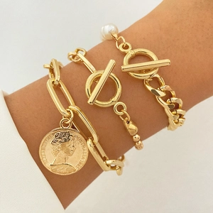 Three-piece gold layered bracelet set featuring coin pendant, pearl accents, and toggle clasps