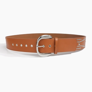 Detail of brown leather belt with silver moon-shaped buckle, eyelets and rivets