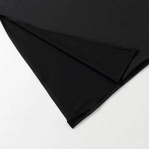 Close-up of precision stitching and split hem detail on a black high-elasticity dress