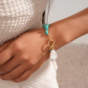 Detailansicht von OT-Verschluss, Türkis-Perlen und Barockperle auf goldenem Armband