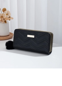 Detail view of black V-quilted women long wallet with dual zippers and pompom
