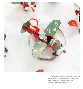 Close-up of metal Christmas airplane ornament with snowman pilot on snowy background