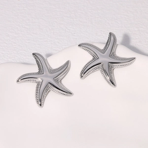 Macro detail of silver starfish stud earrings with frosted texture and polished edges