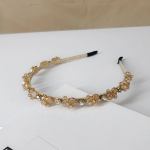 Detailed macro view of champagne crystal headband with sparkling rhinestones and gold base
