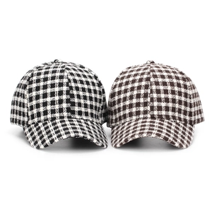 Detail of black and brown houndstooth tweed baseball caps showing fabric texture