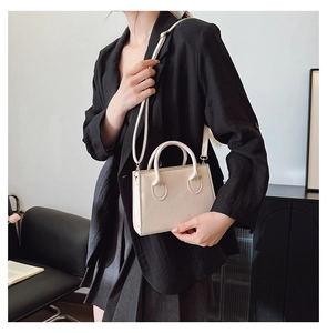 Chic cream-white crossbody bag styled on model with sleek rectangle shape and PU leather