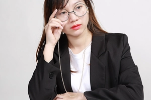 Detail of yellow beaded eyewear chain with silicone non-slip loops worn by a model